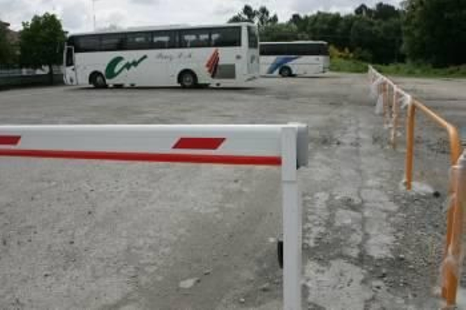 Vallas de seguridad en el exterior del colegio de A Uceira, con autobuses estacionados al fondo. (Foto: Marcos Atrio)