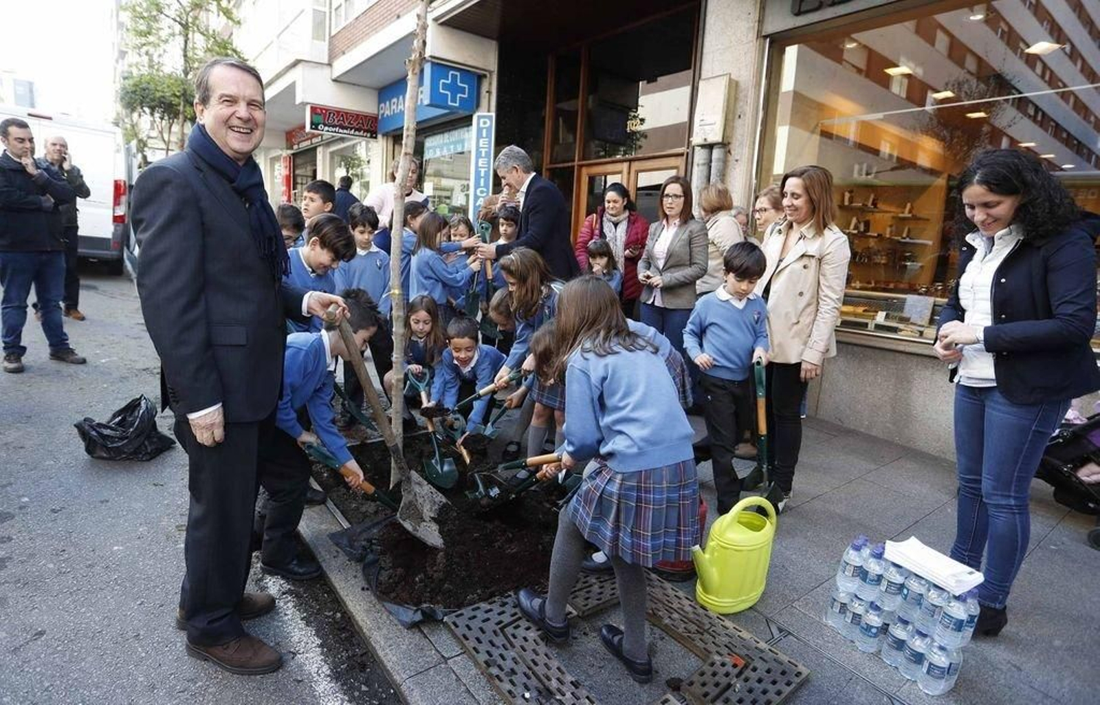 Caballero con alumnos del colegio Alba plantando olivos en el Día del Árbol.