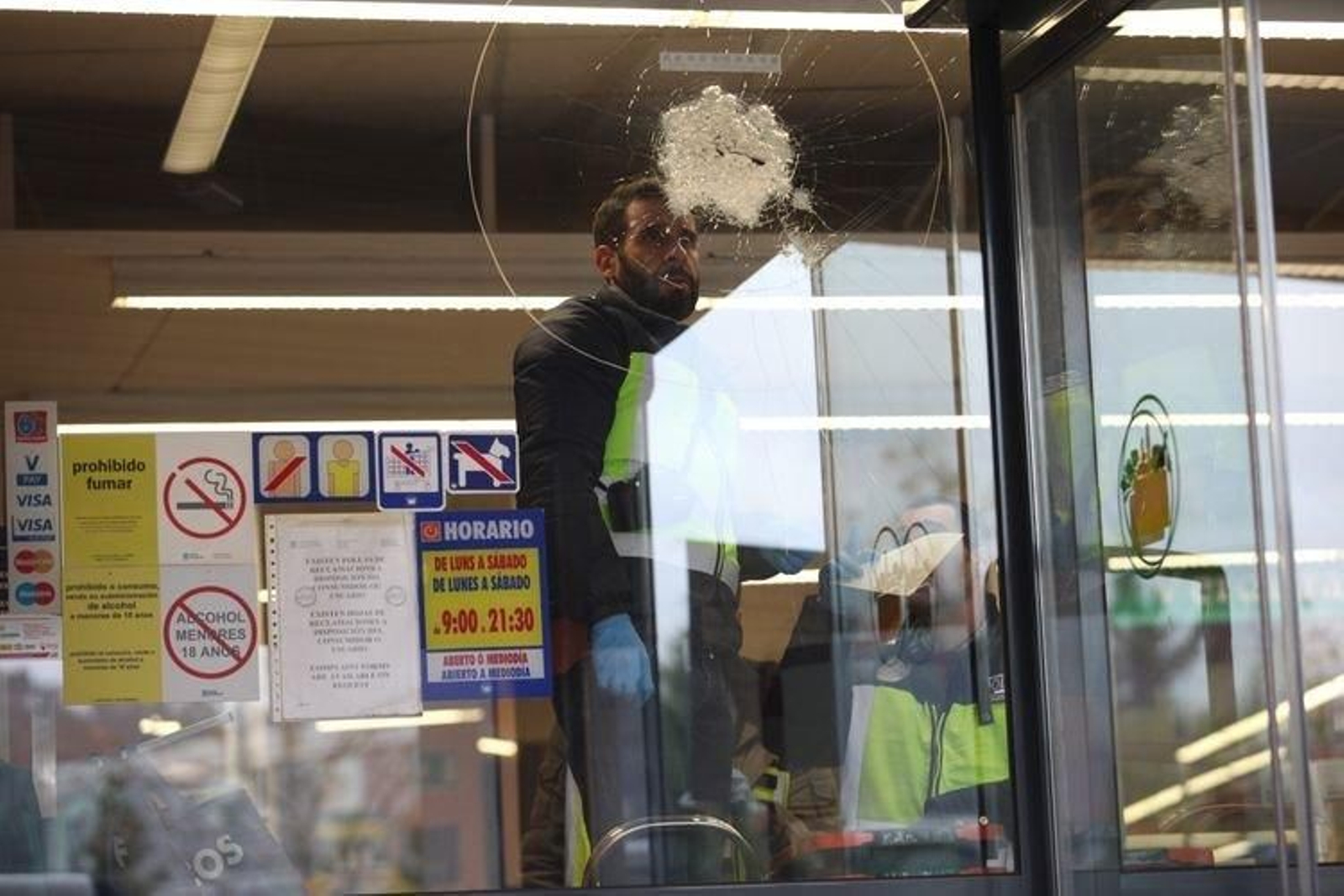 Un policía investiga uno de los impactos del arma.