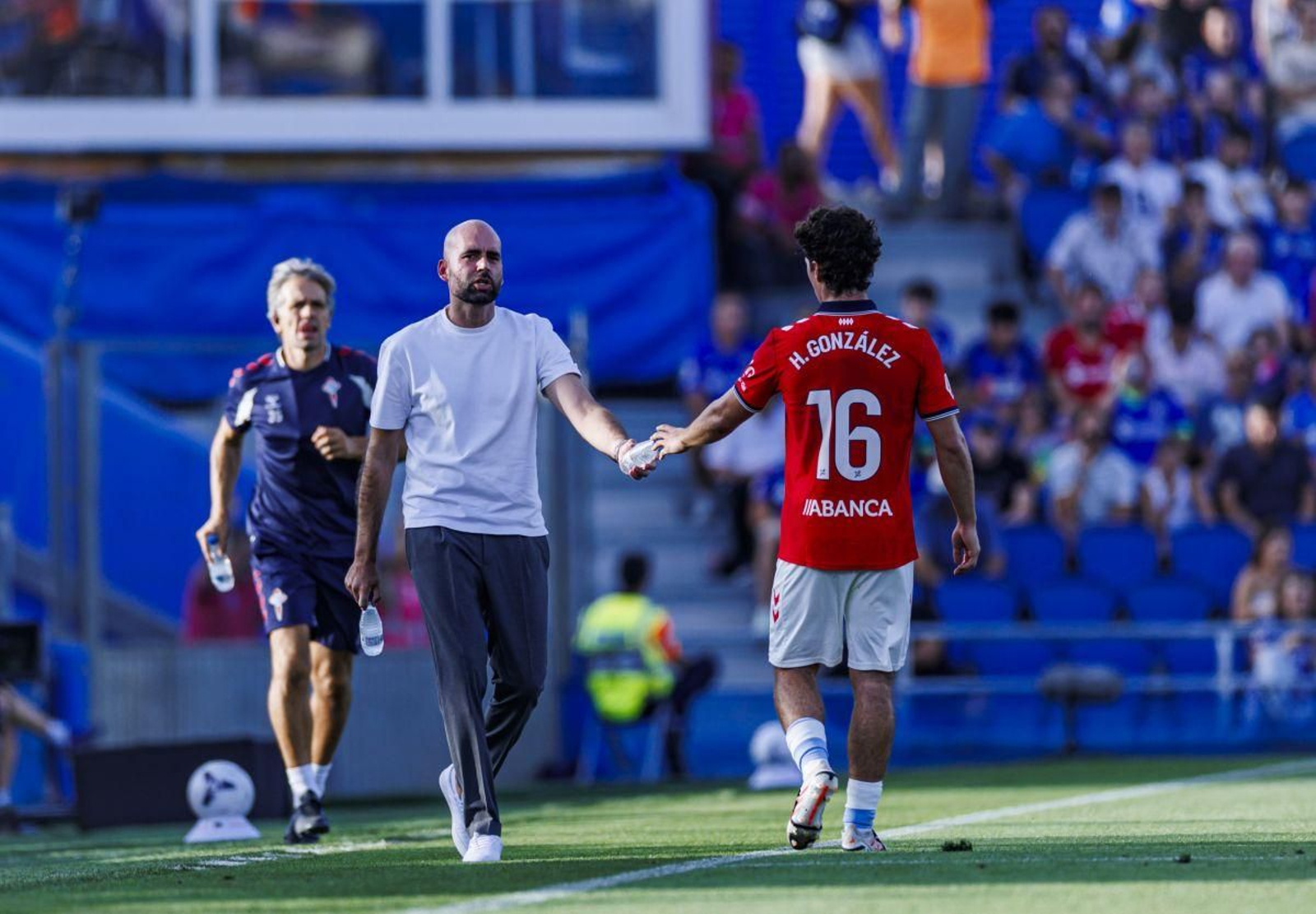 Claudio Giráldez le da una botella de agua a Hugo González, ayer durante el partido ante el Getafe en el Coliseum.