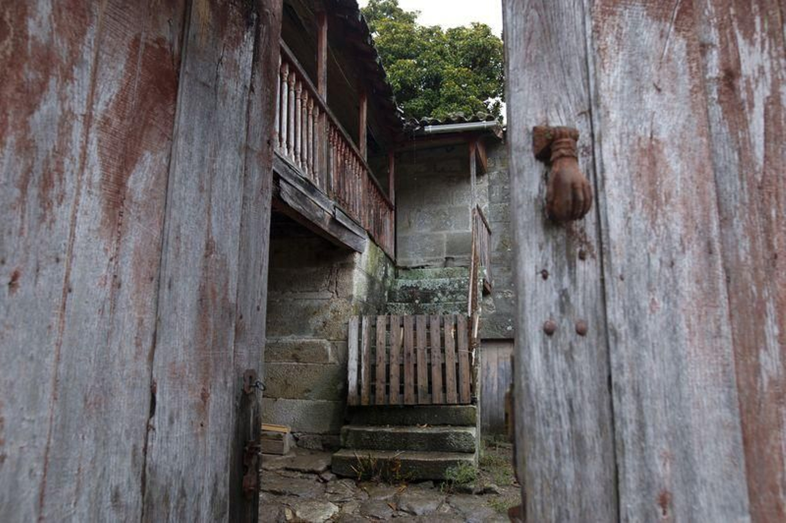 Portón entreabierto de la casa familiar de Xaquín Lourenzo Xocas, propiedad del Concello de Lobeira. (Foto: Martiño Pinal)