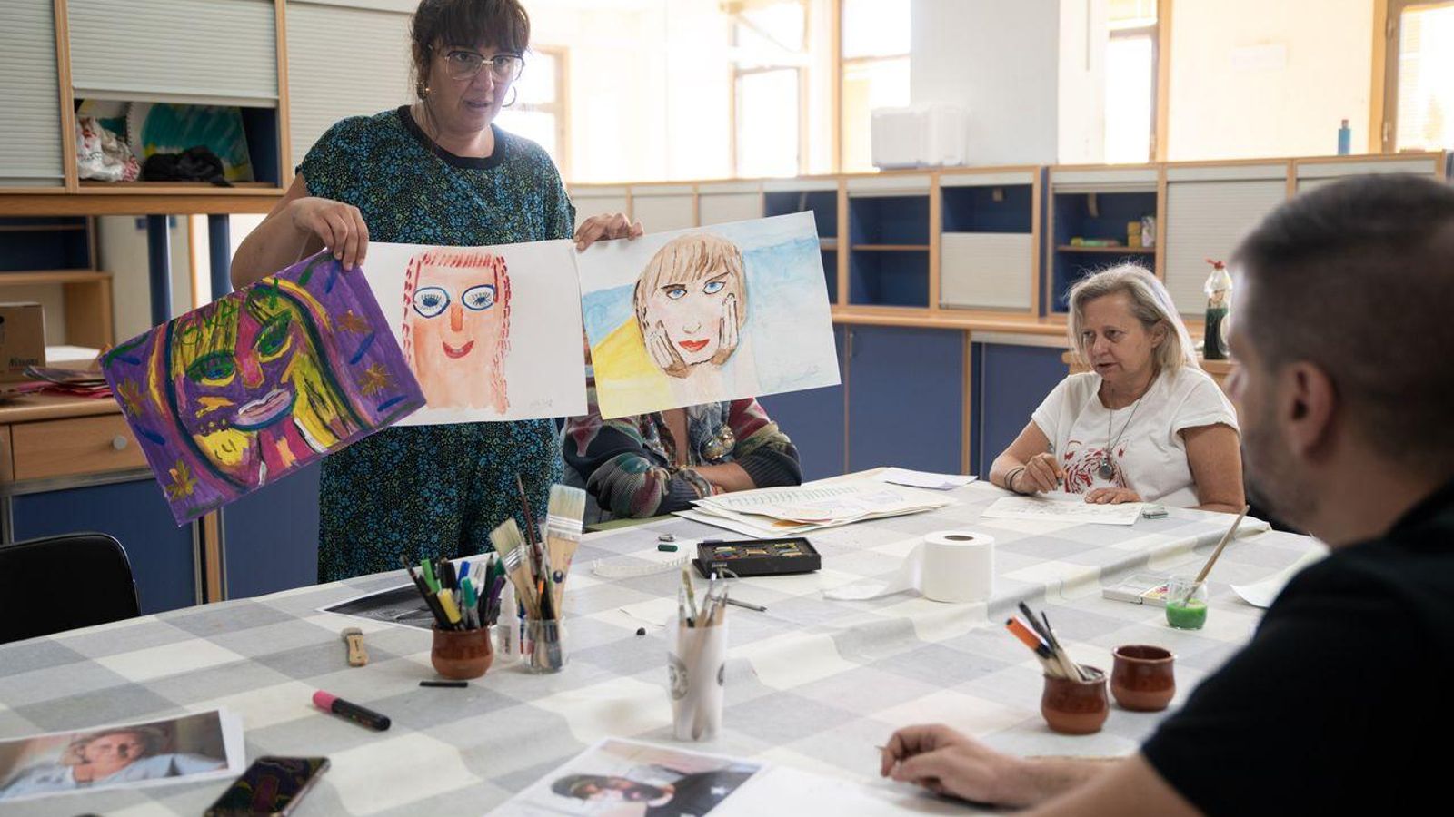 La psicóloga Marta García muestra retratos hechos en el taller.  FOTO: ÓSCAR PINAL