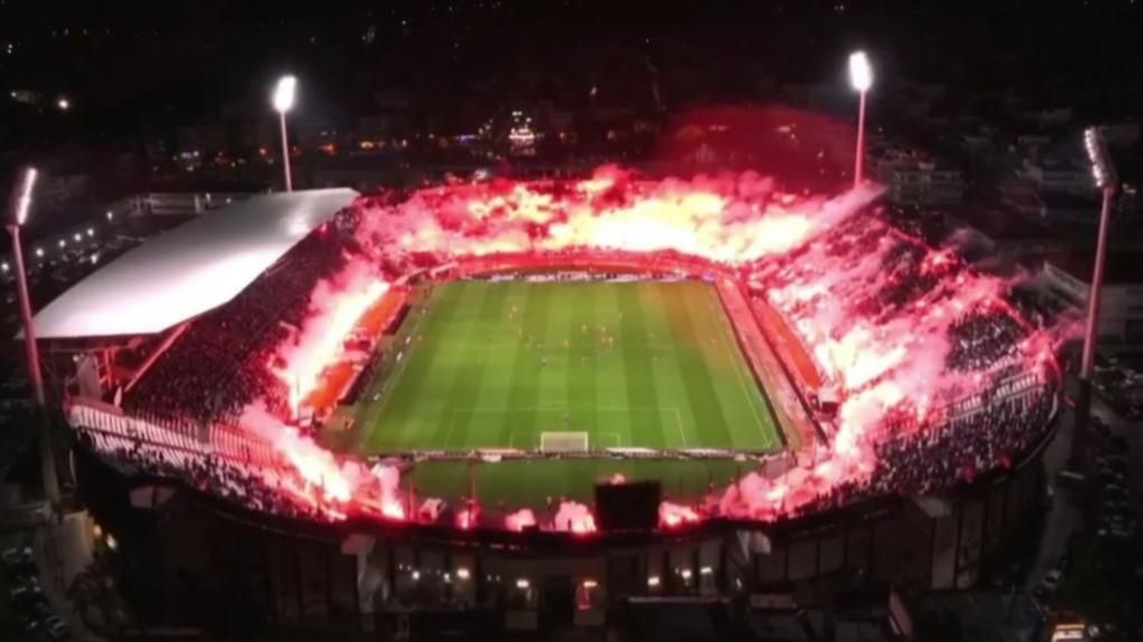 El estadio del PAOK iluminado con las bengalas de los aficionados.