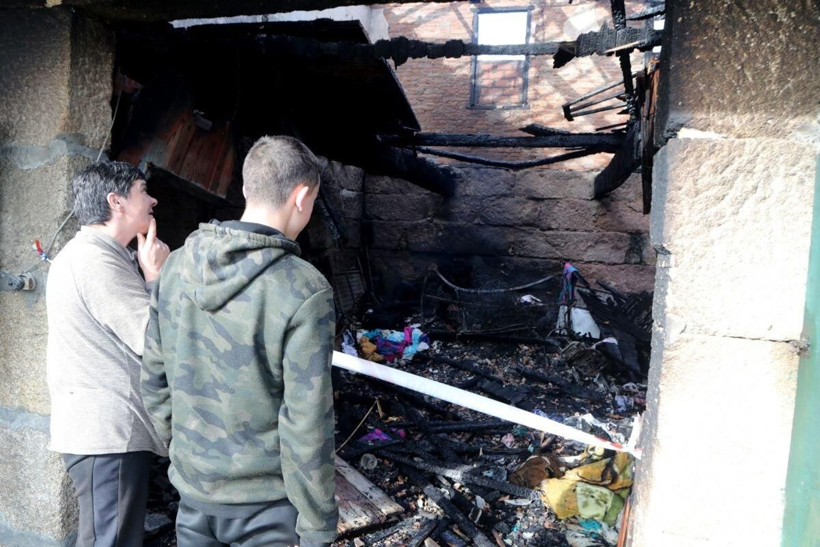 Los vecinos del afectado observan el estado en el que quedó la vivienda.