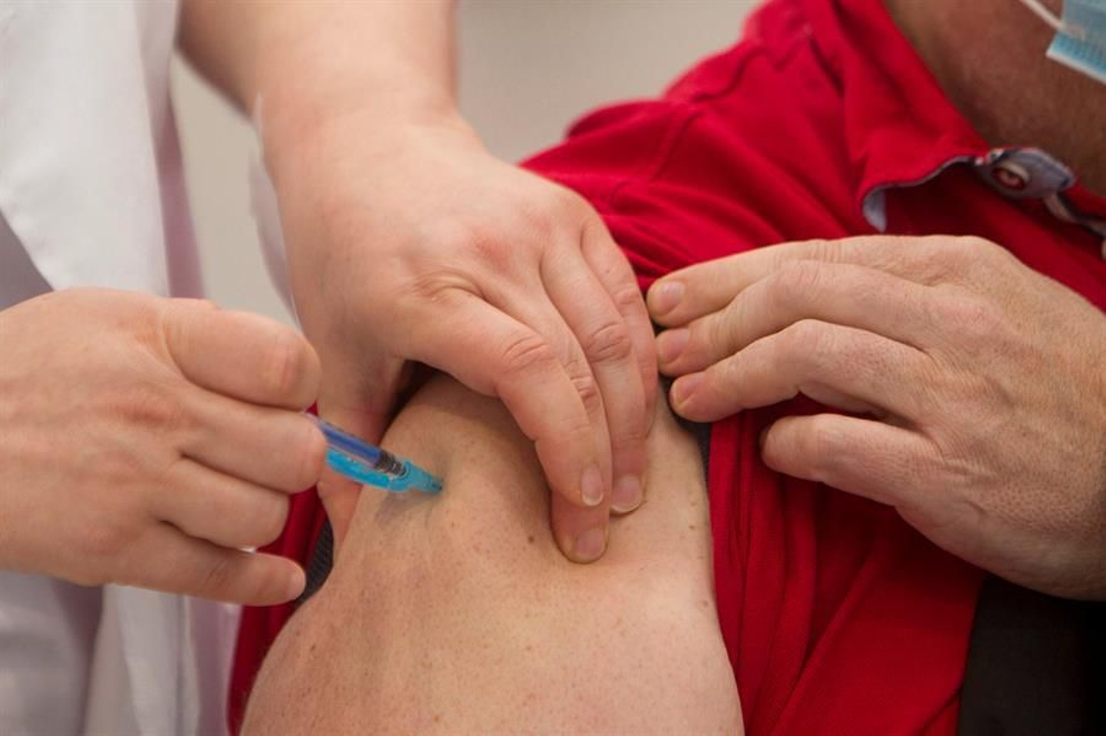 Una trabajadora sanitaria vacuna a un hombre contra el coronavirus.