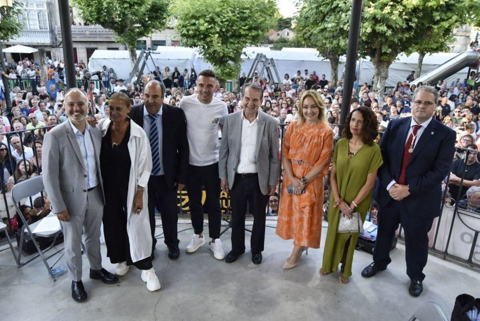 Iago Aspas, acompañado por David Regades, Carmela Silva, Javier Grande (comisión de fiestas), Abel Caballero, Marian Mouriño e Íñigo Andonigui (cofrade mayor), entre otros, ante una Alameda con el aforo completo para el pregón, amenizado por la banda de música de A Lama.