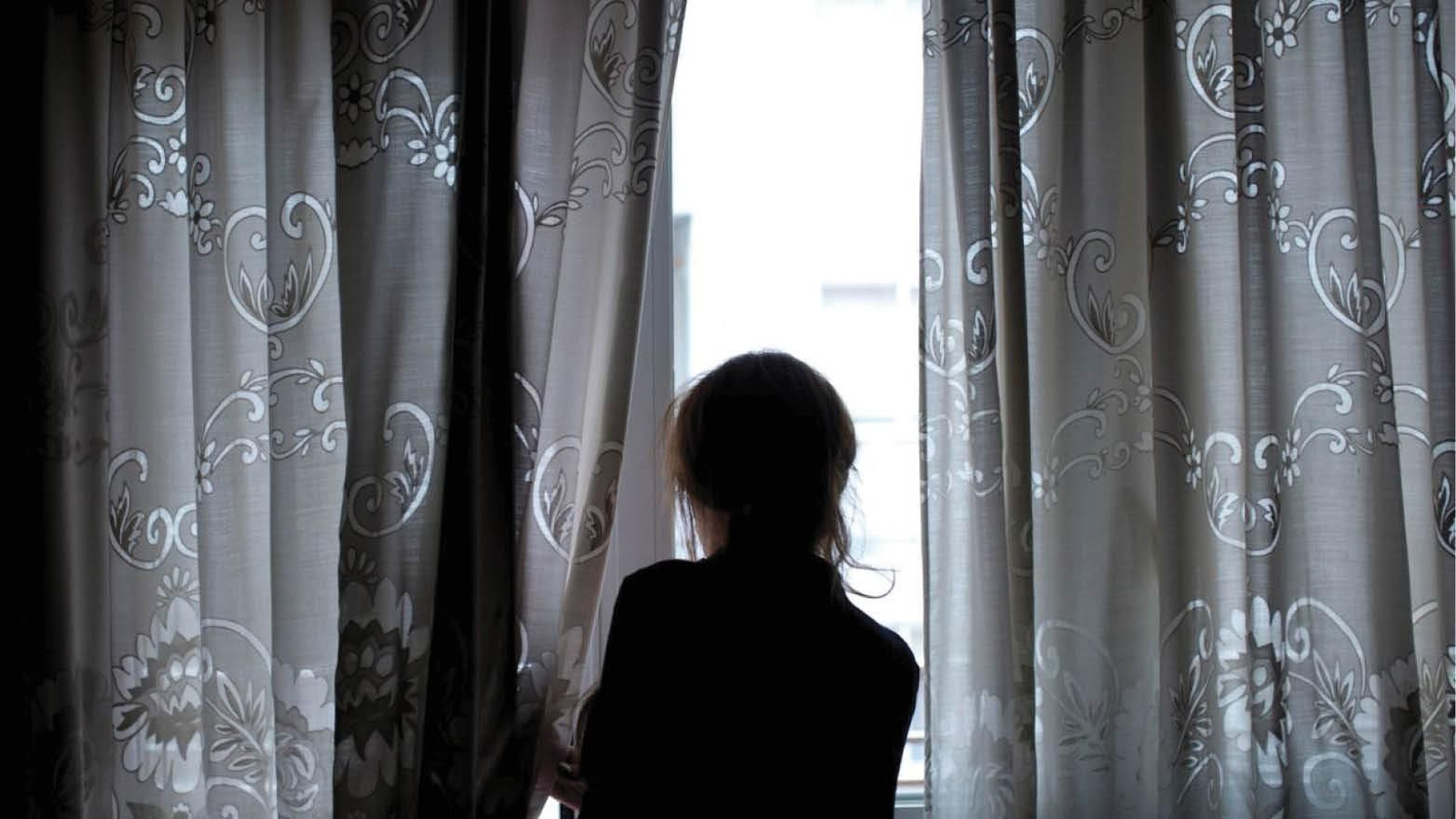 Una mujer mira a través de la ventana durante el confinamiento. (Brais Lorenzo)