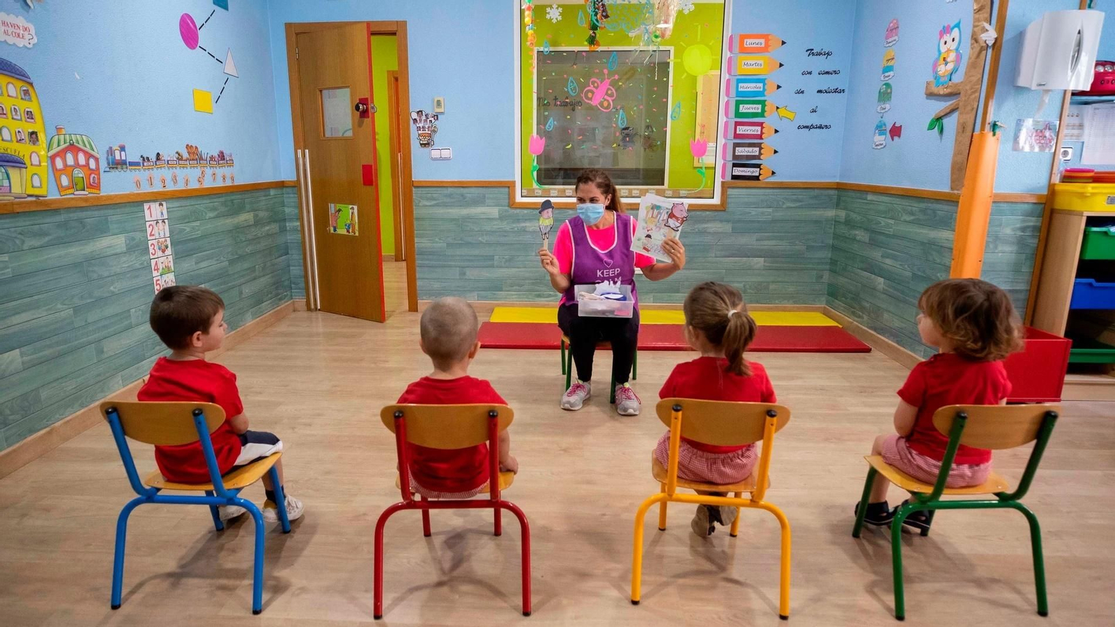 Una educadora de un centro escolar les cuenta un cuento a sus alumnos.