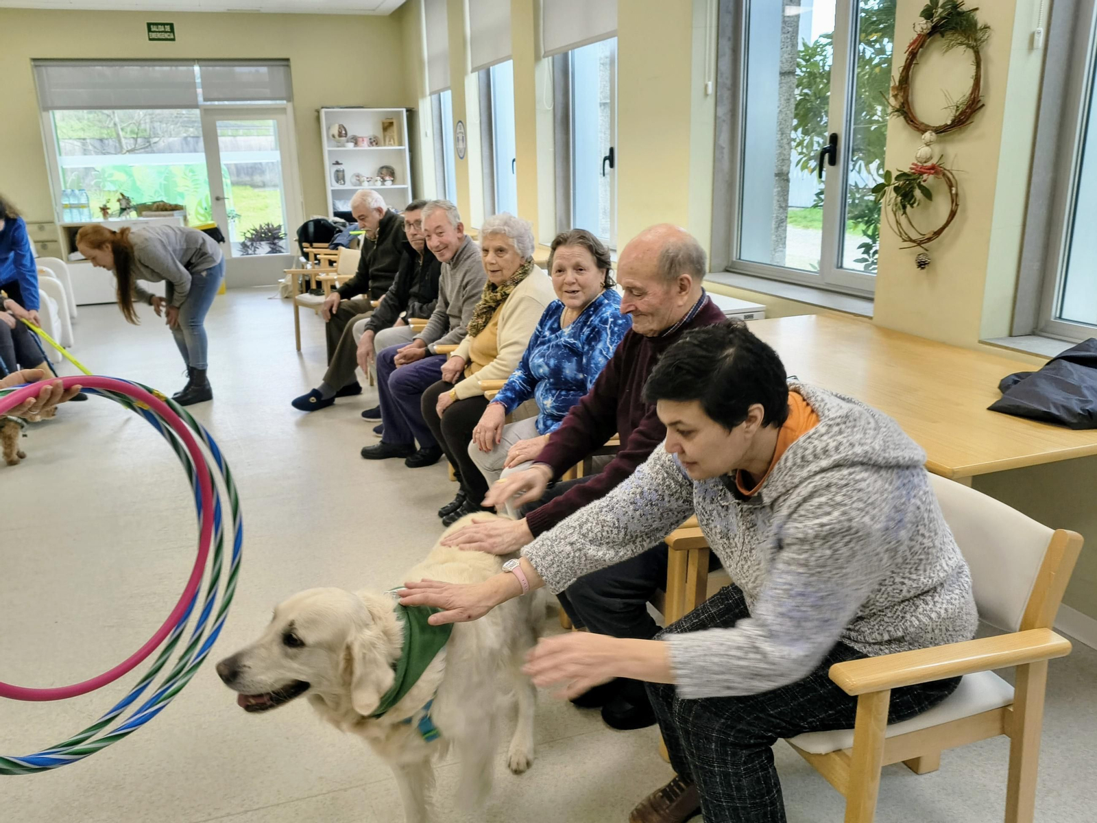 Nanuk y los usuarios del Centro de Día de Cambados hacen uno de los ejercicios grupales con aros.