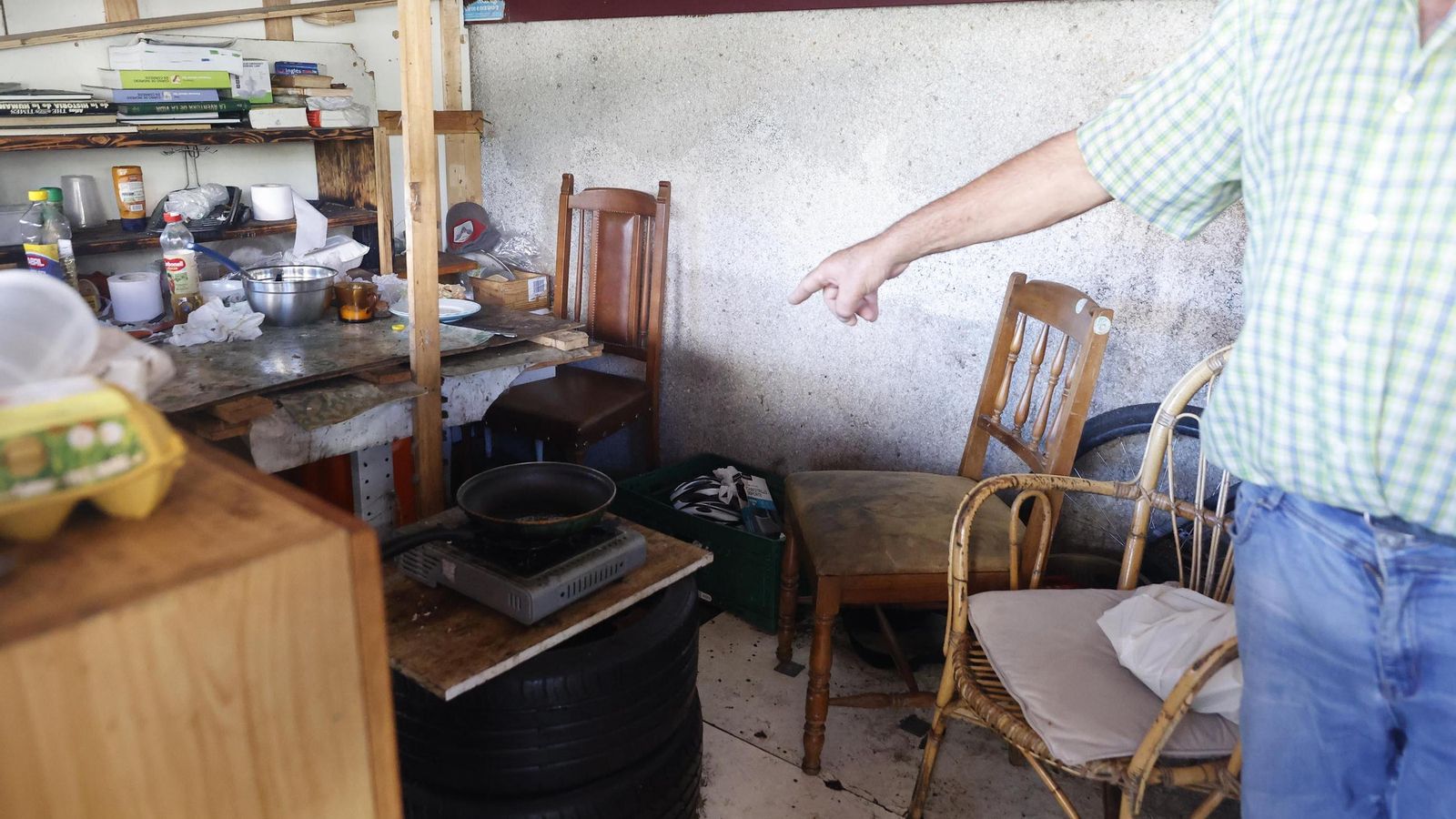 Un hombre muestra la pequeña cocina improvisada que montó en la vieja estación.