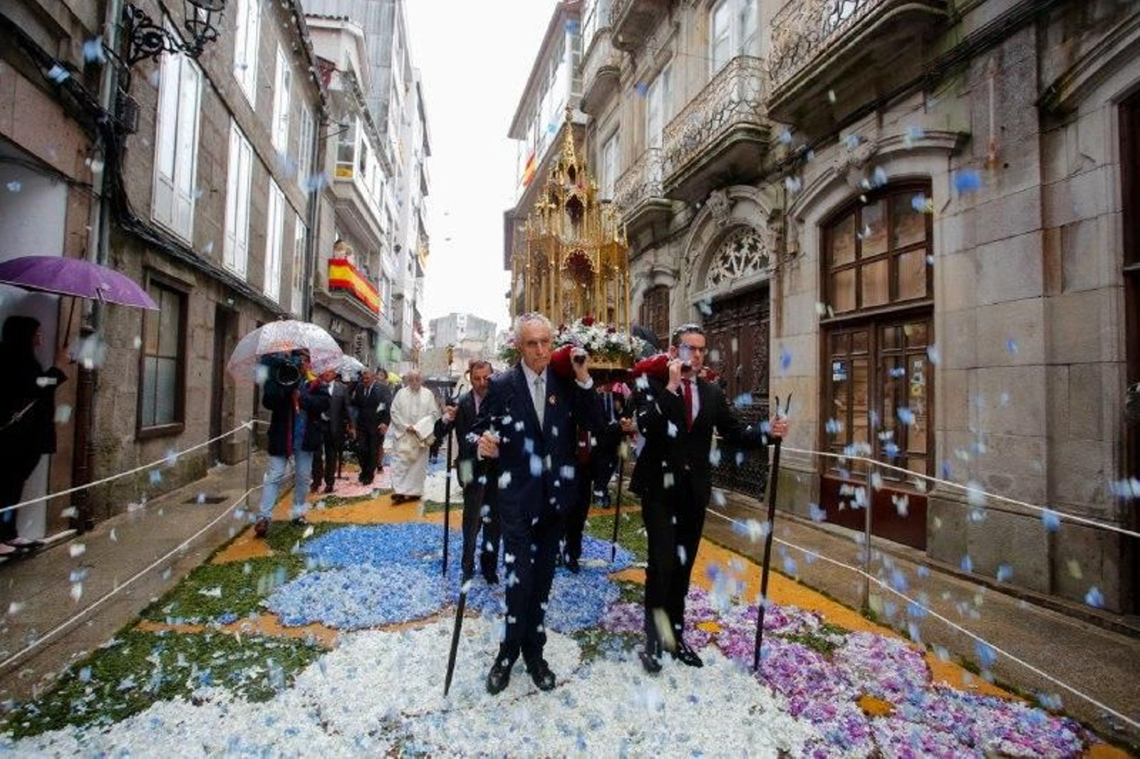 Los asistentes lanzan flores durante la marcha de la procesión