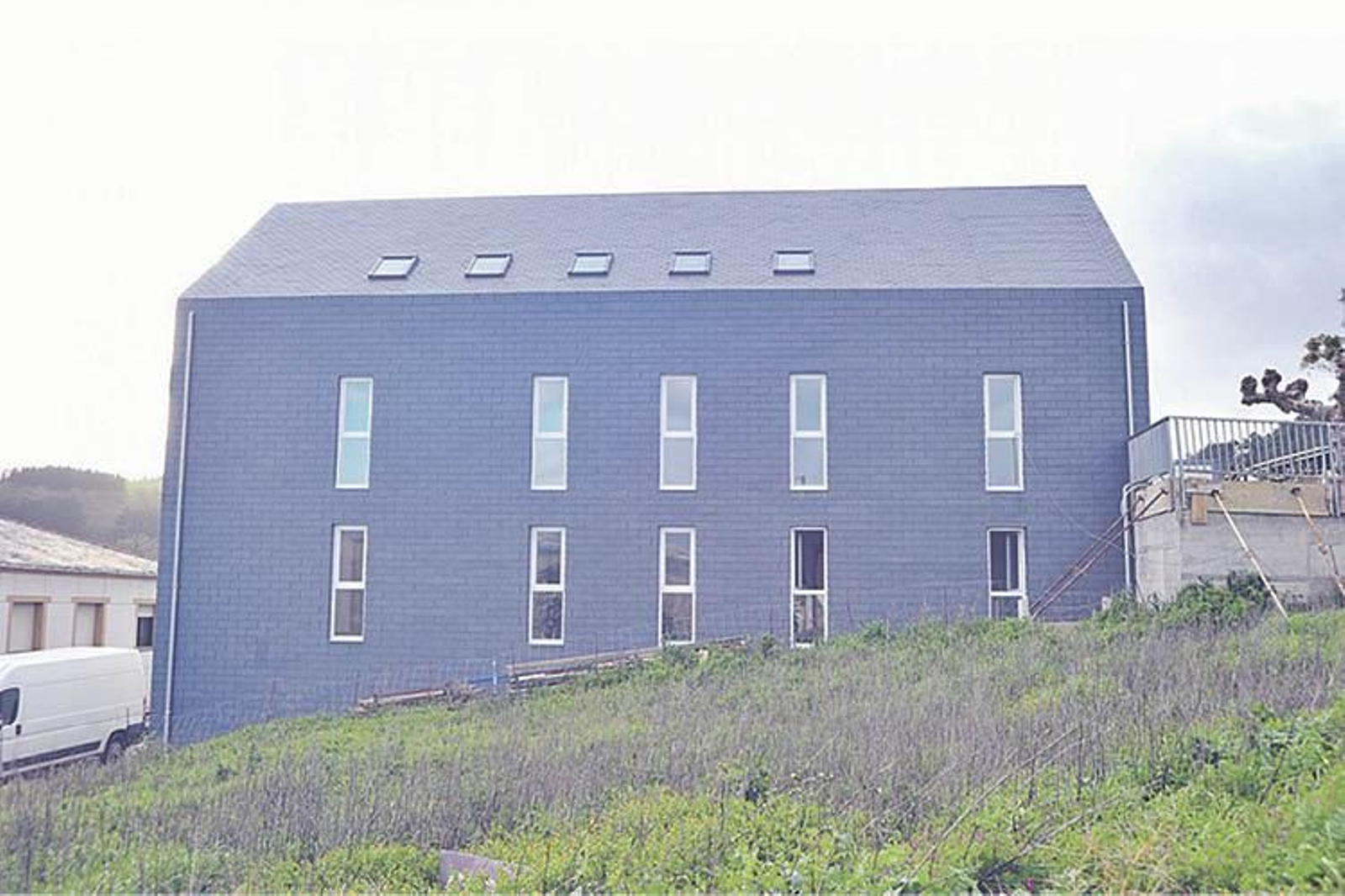 Fachada lateral de pizarra, en el albergue de Portomarín.