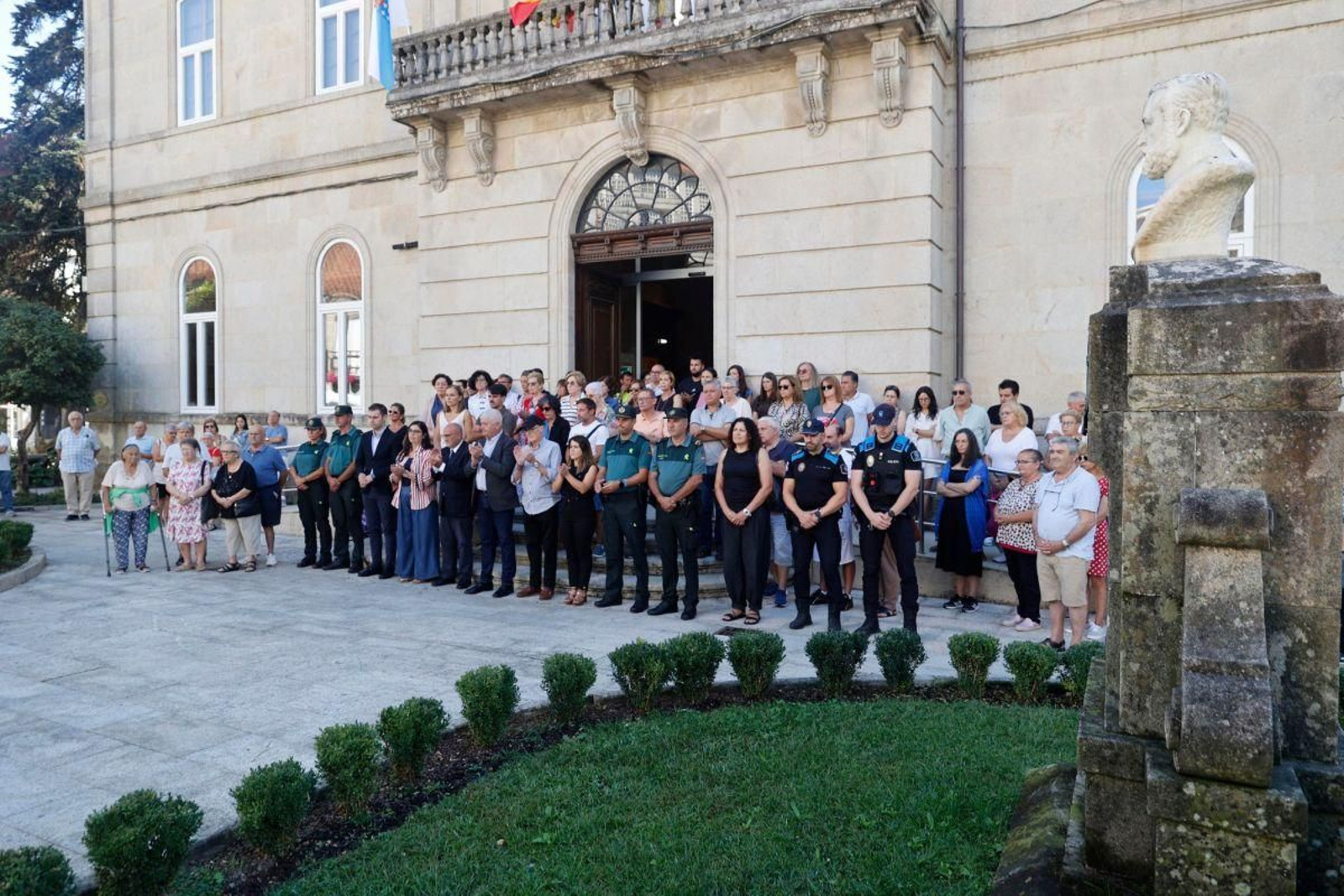 Miembros de la corporación municipal, trabajadores y vecinos, ayer en el minuto de silencio ante  el Concello.