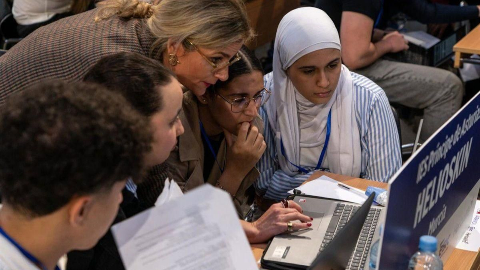 Una profesora explica la asignatura a sus alumnos con un ordenador.