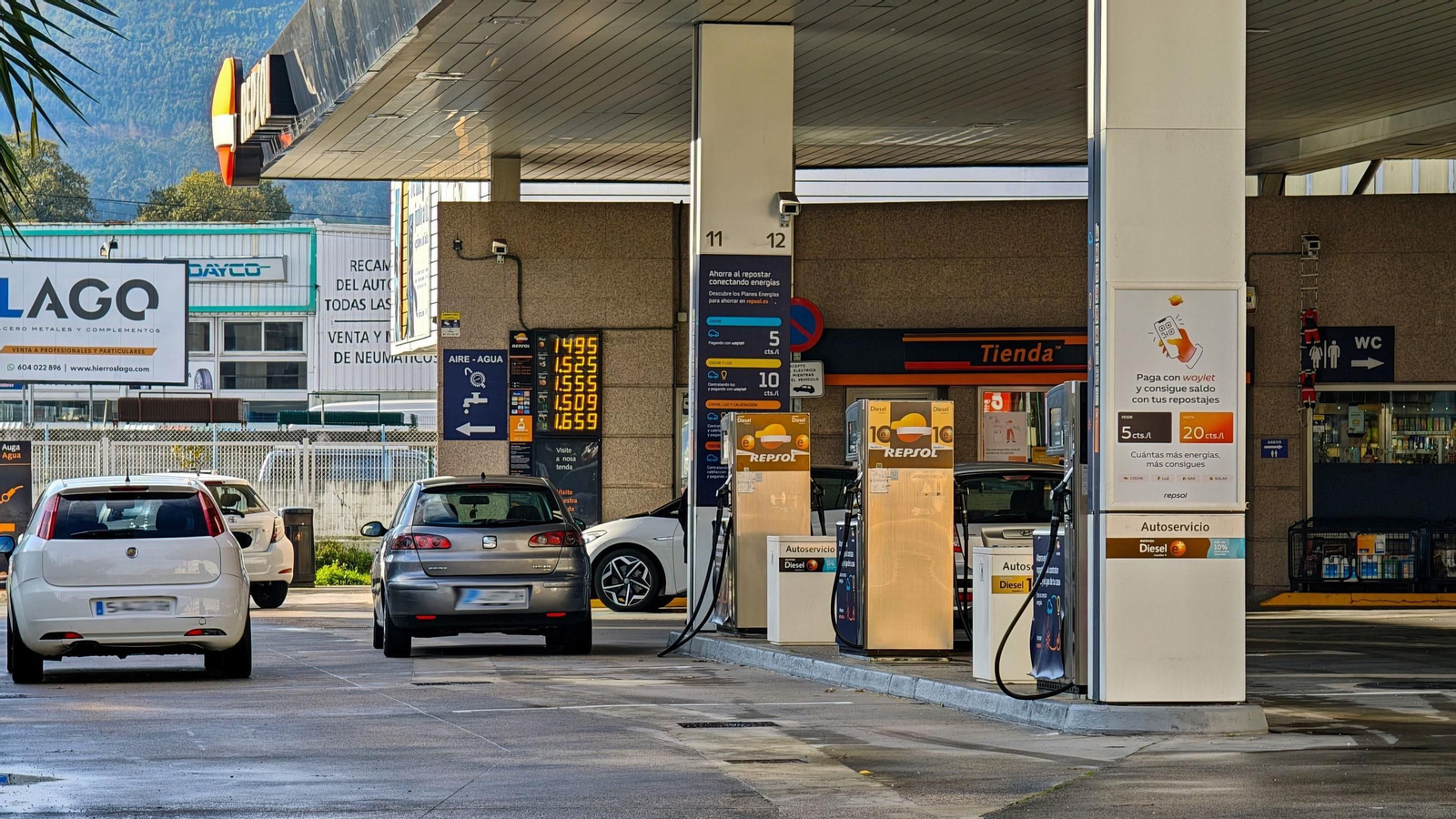 Vehículos repostando en una gasolinera en la ciudad.