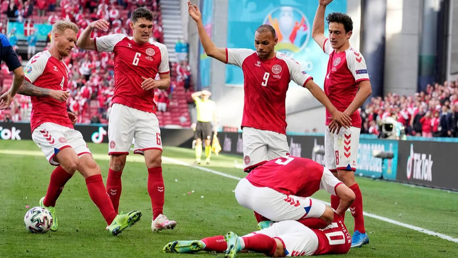 Jugadores de Dinamarca atienden a Eriksen tras su desvanecimiento.
