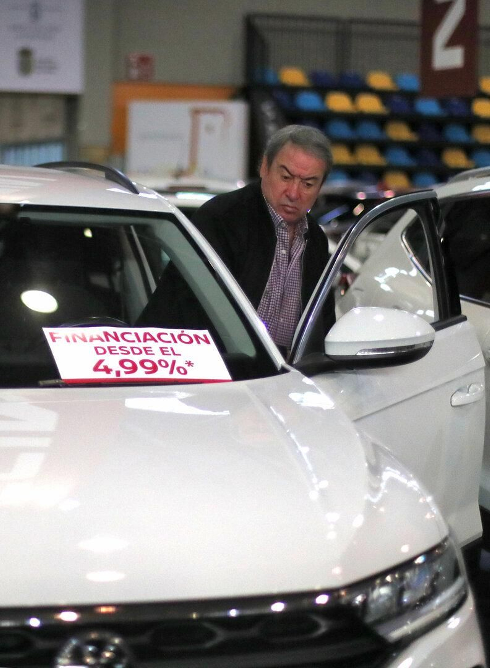 Visitante de la exposición entrando a probar por dentro uno de los coches