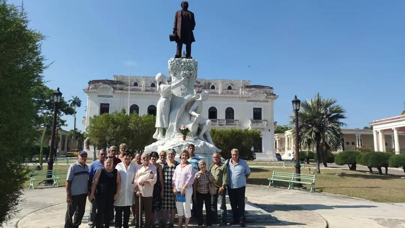 Grupo de asistentes al pie de la estatua de Manuel Valle Fernández en la clínica La Covadonga.