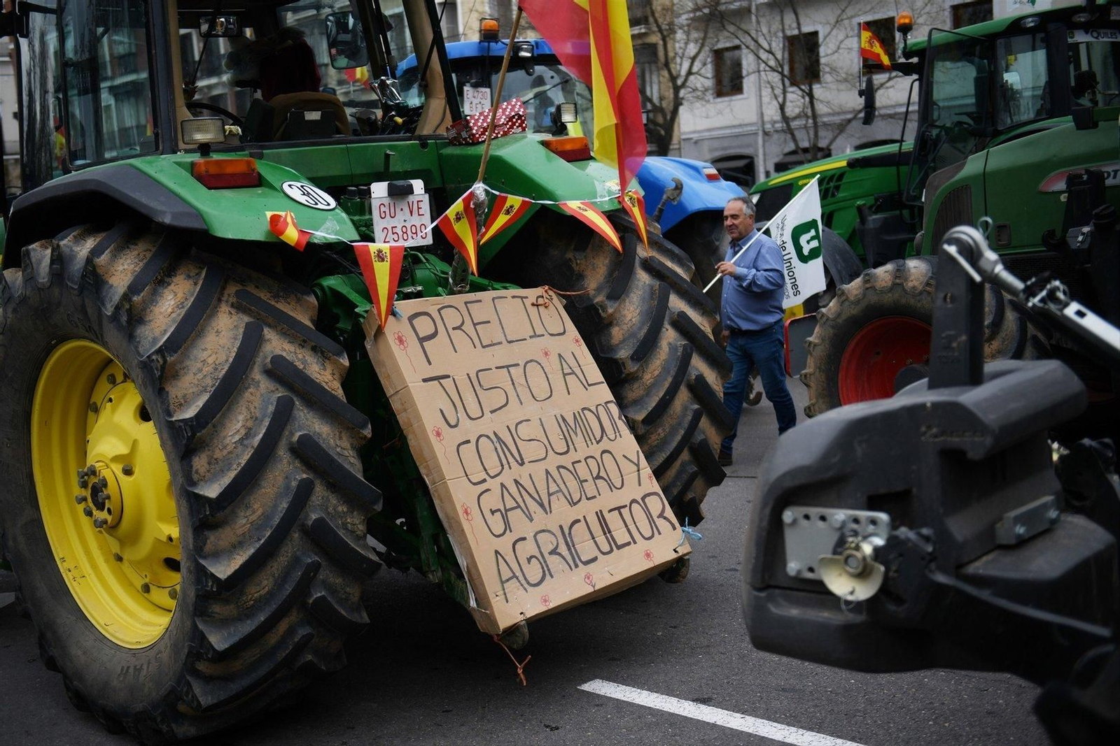 Un tractor con una pancarta en la que se lee: "Precio justo al consumidor, ganadero y agricultor".