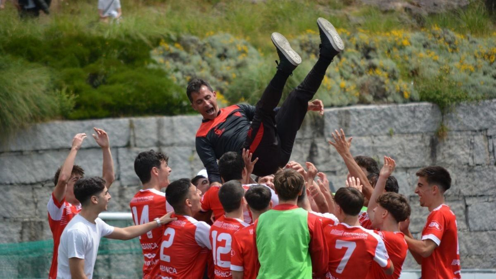 Los futbolistas del Val Miñor celebran el ascenso en Condomínguez con un manteo a su entrenador, Marco Rodríguez.