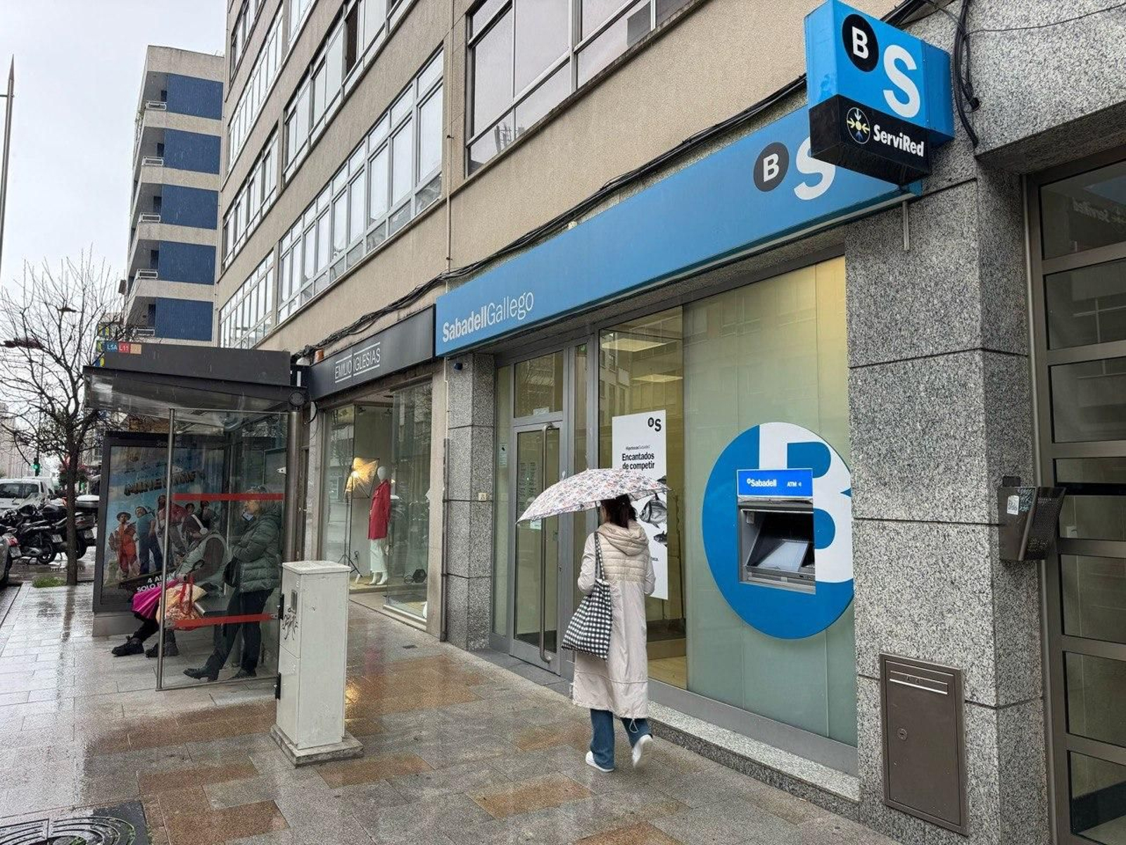 Imagen de la sucursal del Sabadell poco después del atraco, el pasado viernes. La  nueva marquesina de autobús, delante de la puerta.