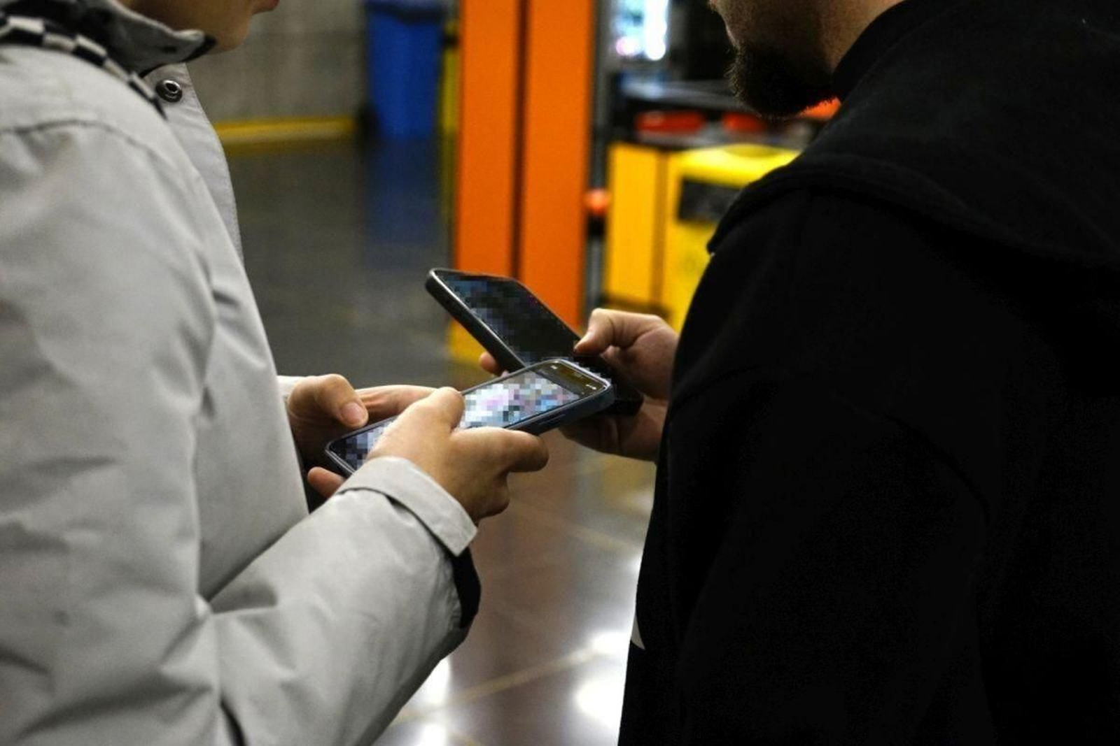 Dos jóvenes manejando sus teléfonos.