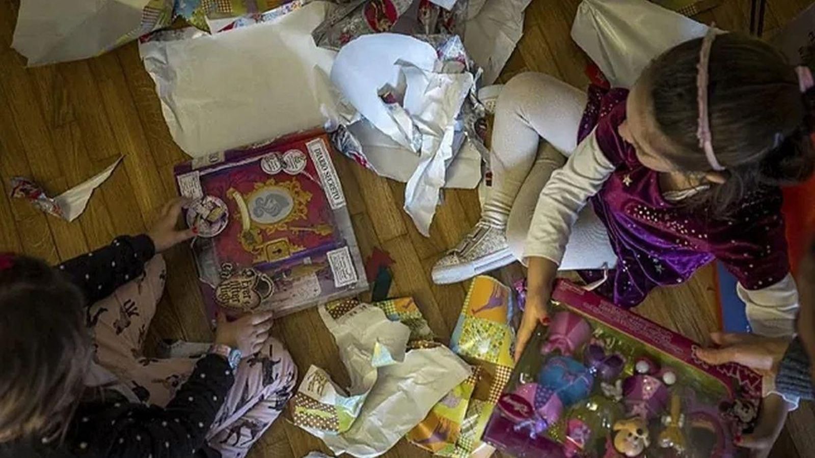 Unas niñas abren los regalos de Navidad.