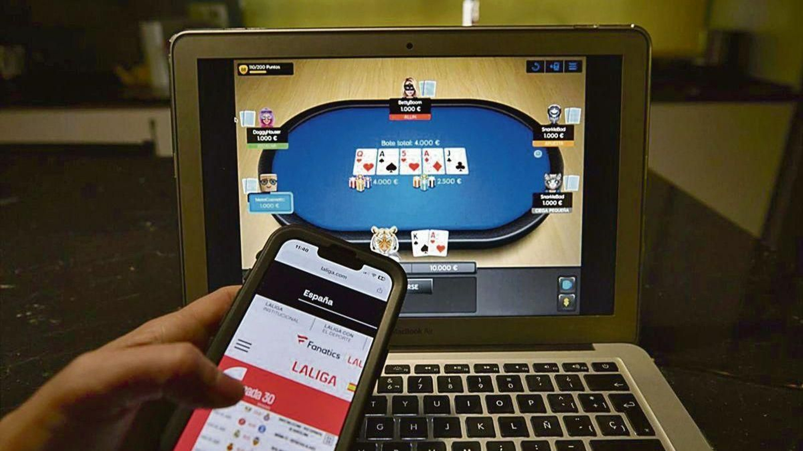 Una persona consulta su móvil mientras participa en una partida de póker online.