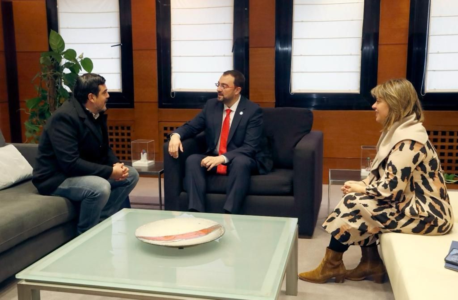 El presidente del Principado, Adrián Barbón, y la vicepresidenta y consejera de Presidencia, Igualdad, Turismo y Reto Demográfico, Gimena Llamedo, durante su reunión con Juan Manuel de Hoz, portavoz del Centro de Descendientes de Españoles Unidos (CeDEU).