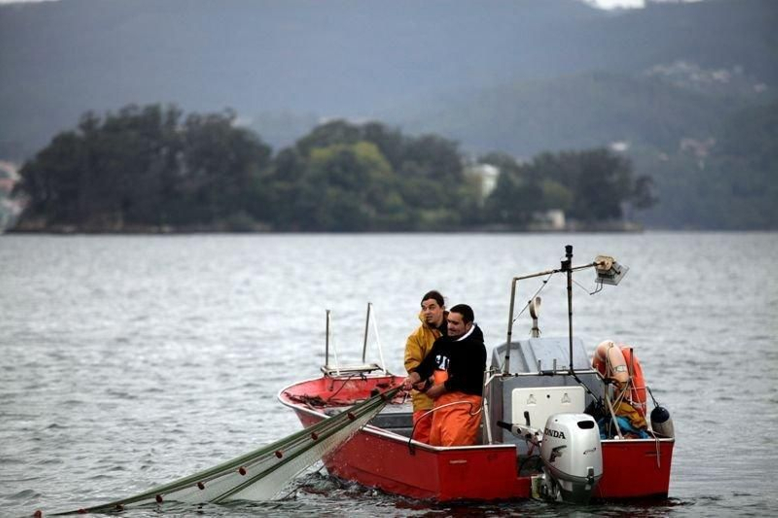 Pescadores de Redondela, ayer mostrando cómo se larga el aparejo en un barco del 'xeito'.