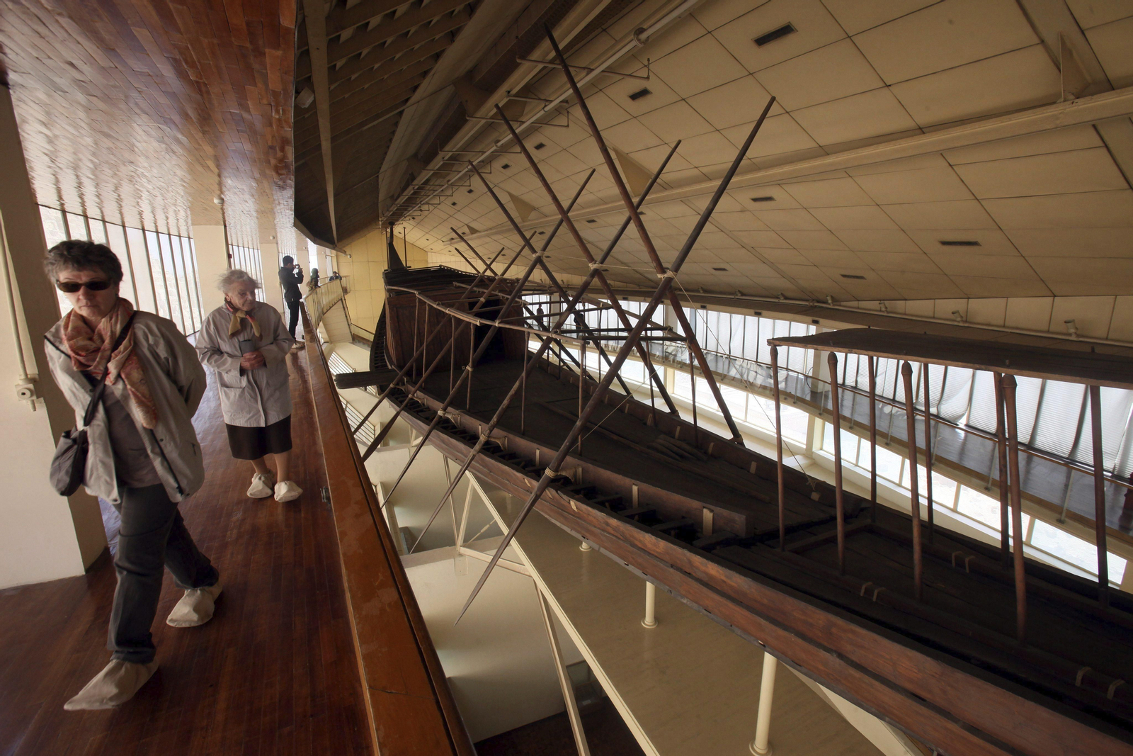 Varios visitantes observan la barca solar de Keops, en el museo ante la gran pirámide en Guiza, Egipto.