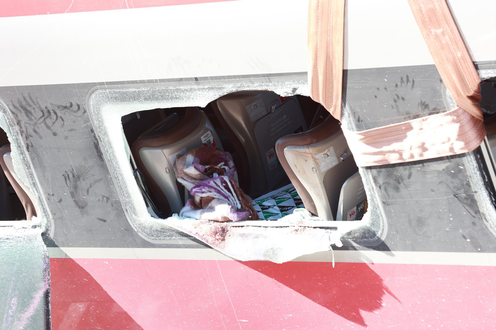 Imagen del interior de un vagón afectado, visible a través de las ventanas fracturadas.