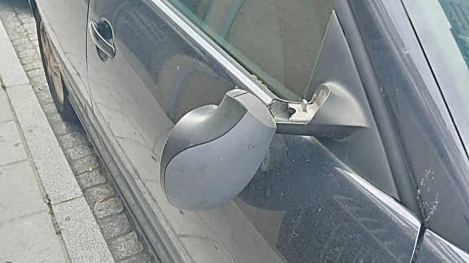 El retrovisor, colgando.