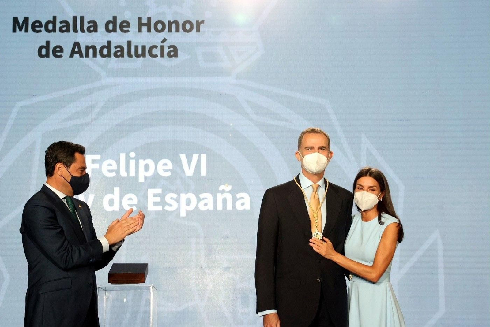 Moreno aplaude al rey, abrazado por la reina, tras la entrega de la Medalla de Honor de Andalucía.