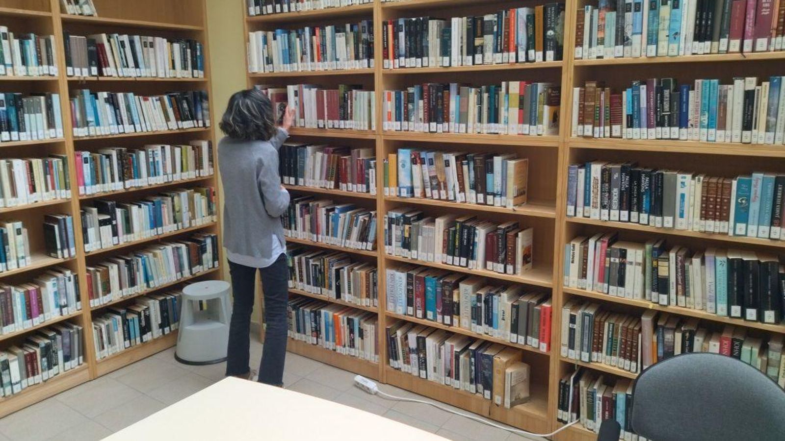 Una bibliotecaria de O Barco deposita un libro.