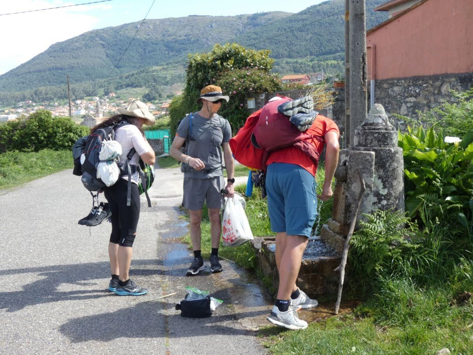 Peregrinos bebiendo en Fonte de Redondelo, en el Concello de Oia.