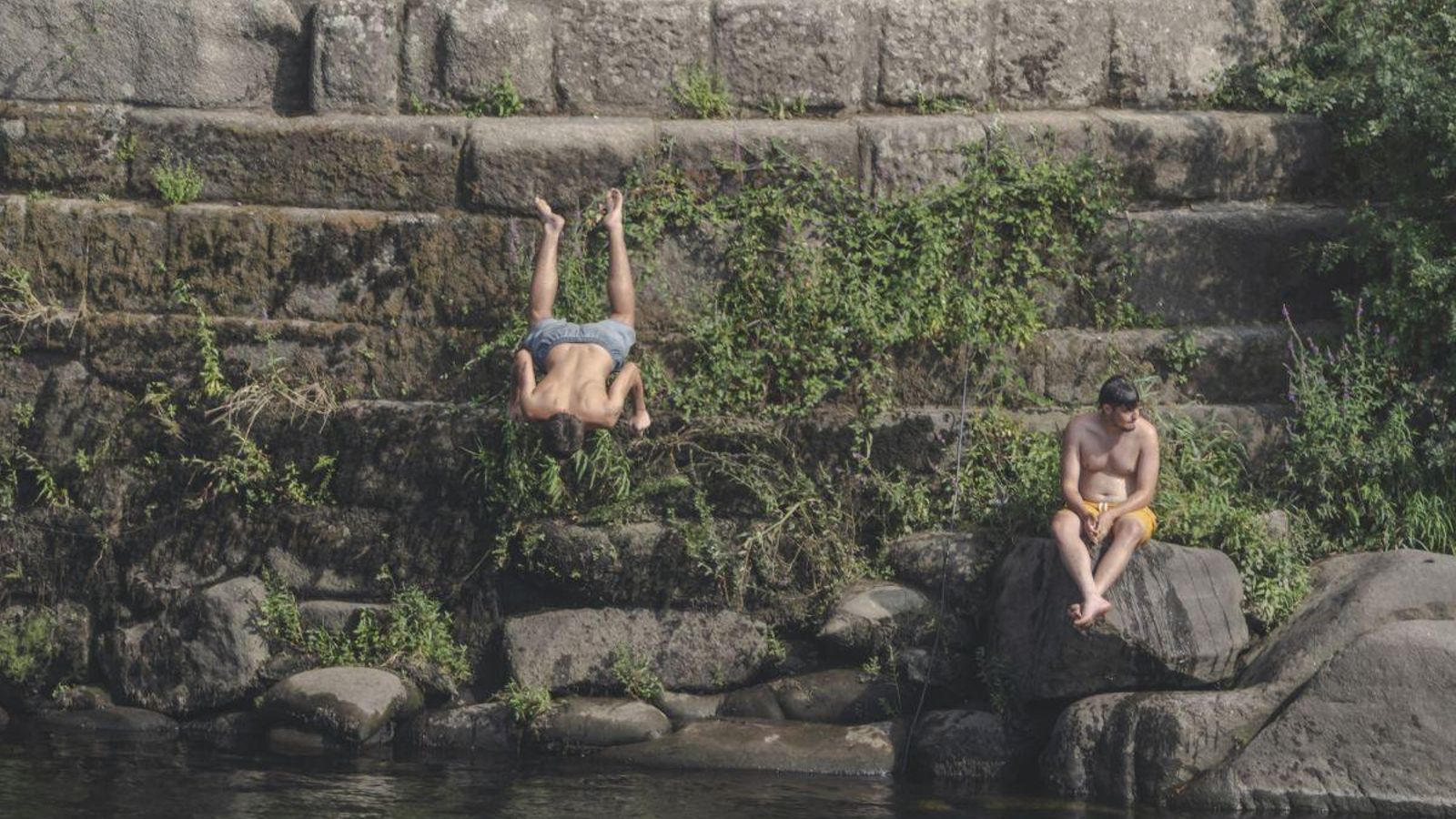 Unos chicos saltando desde el Punte Romano de Ourense, zona peligrosa para el baño.