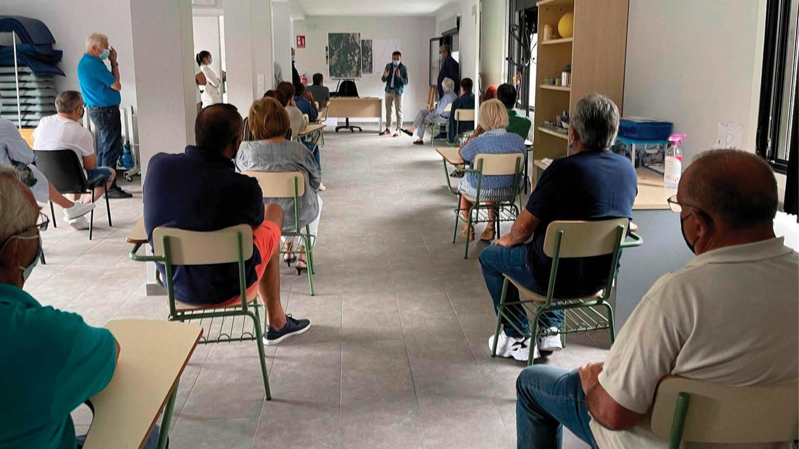 Los vecinos escuchan la explicación del conselleiro.