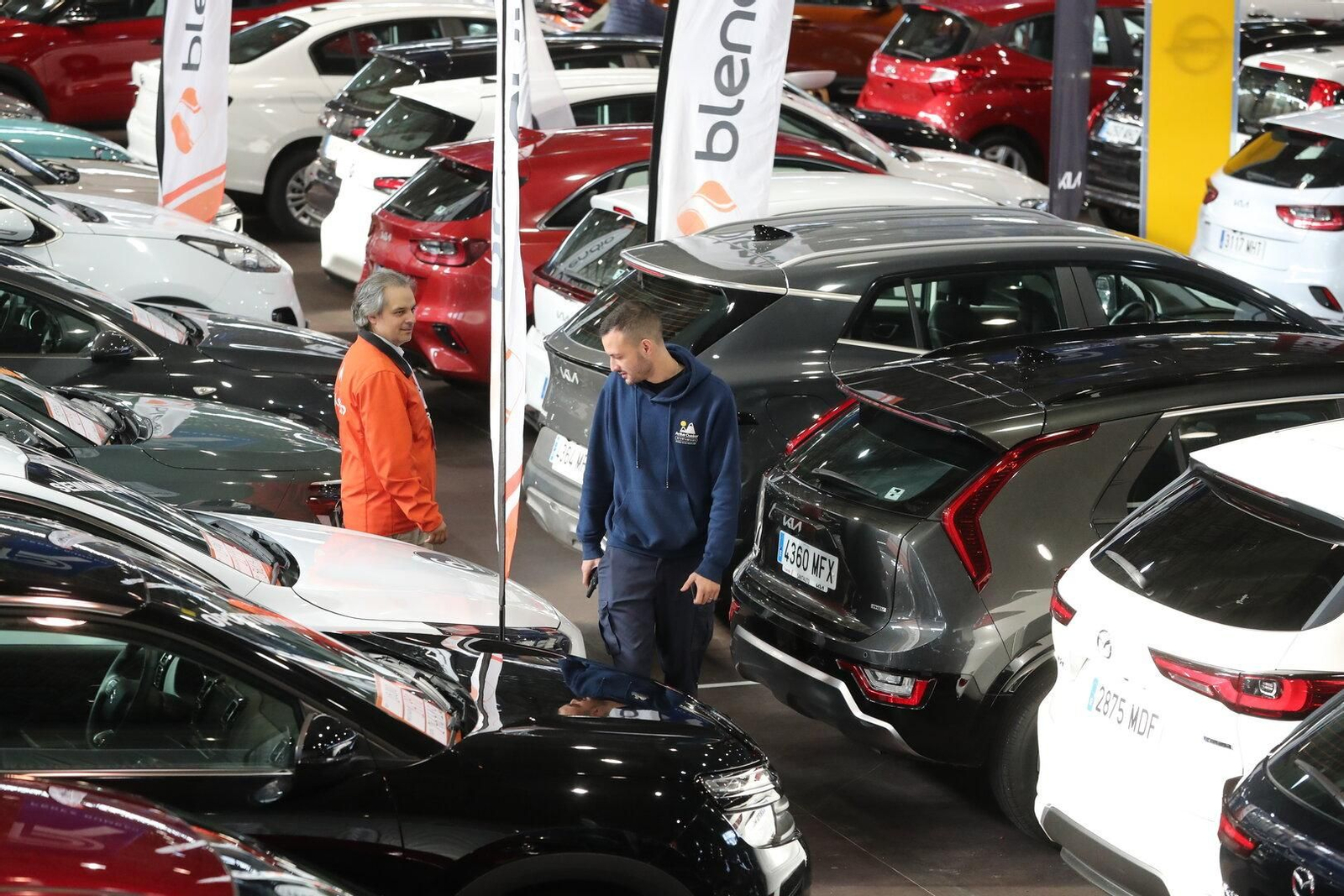 Uno de los visitantes observa muy detenidamente uno de los coches de ocasión del salón