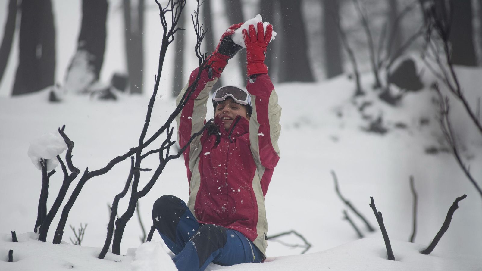 Un niño juega con la nieve.