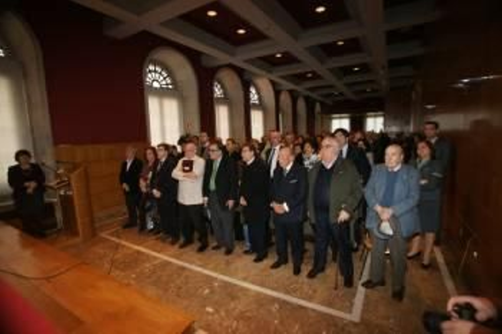 Los 90 asistentes al encuentro de Vigueses Distinguidos, en pie, mientras se nombraban a los fallecidos. VICENTE