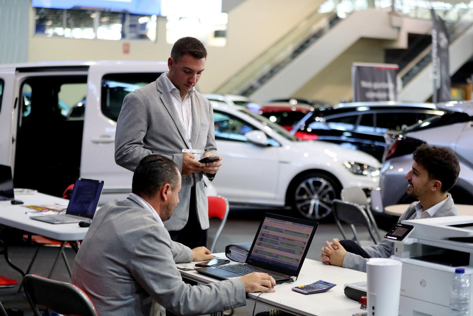 Trabajadores del salón ultiman los últimos detalles antes de recibir a los primeros interesados por los coches de ocasión