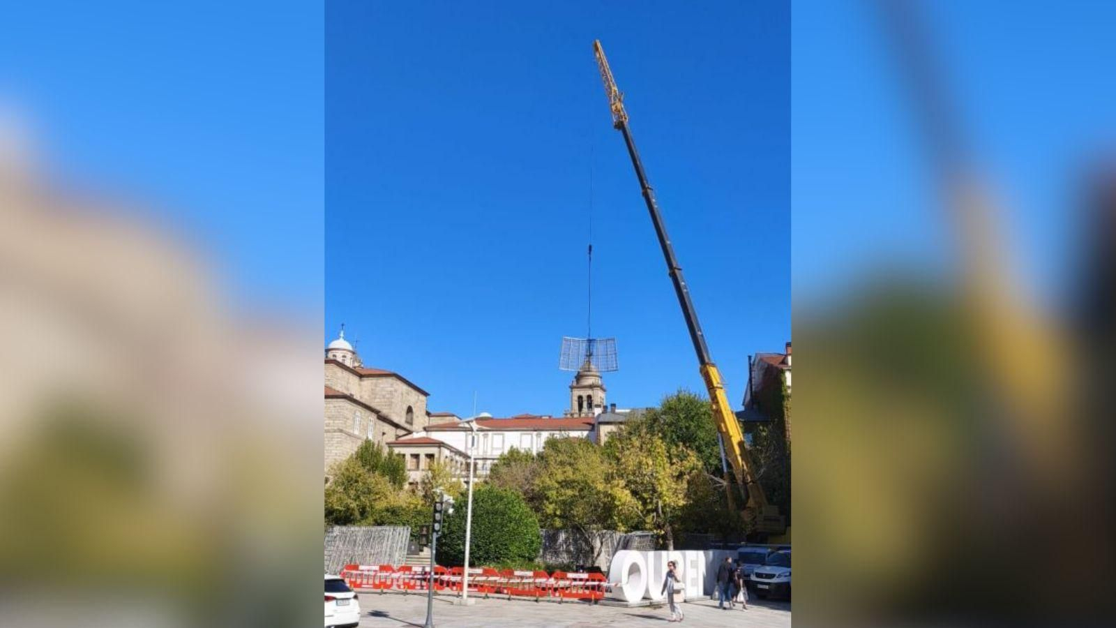 Una grúa colocando el árbol de Navidad en la fuente de Obispo Cesáreo