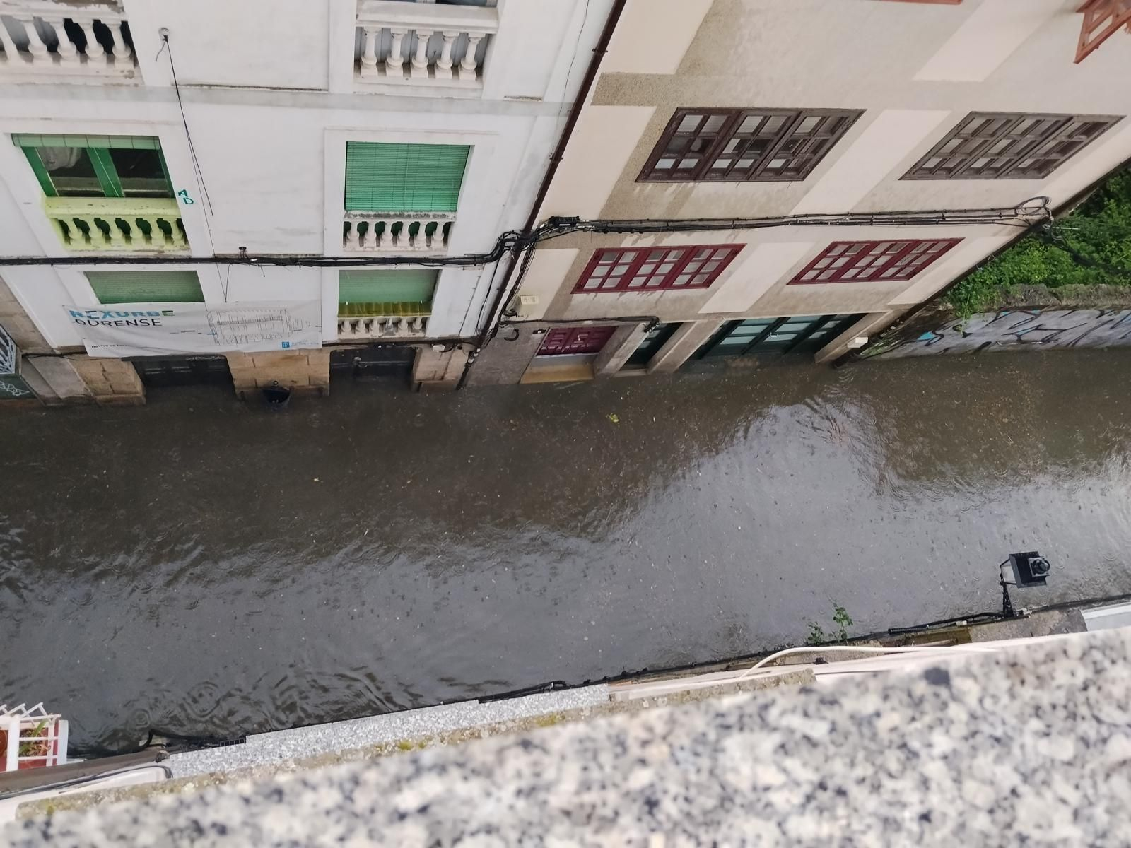 La rúa Colón en plena riada tras la tormenta de este domingo