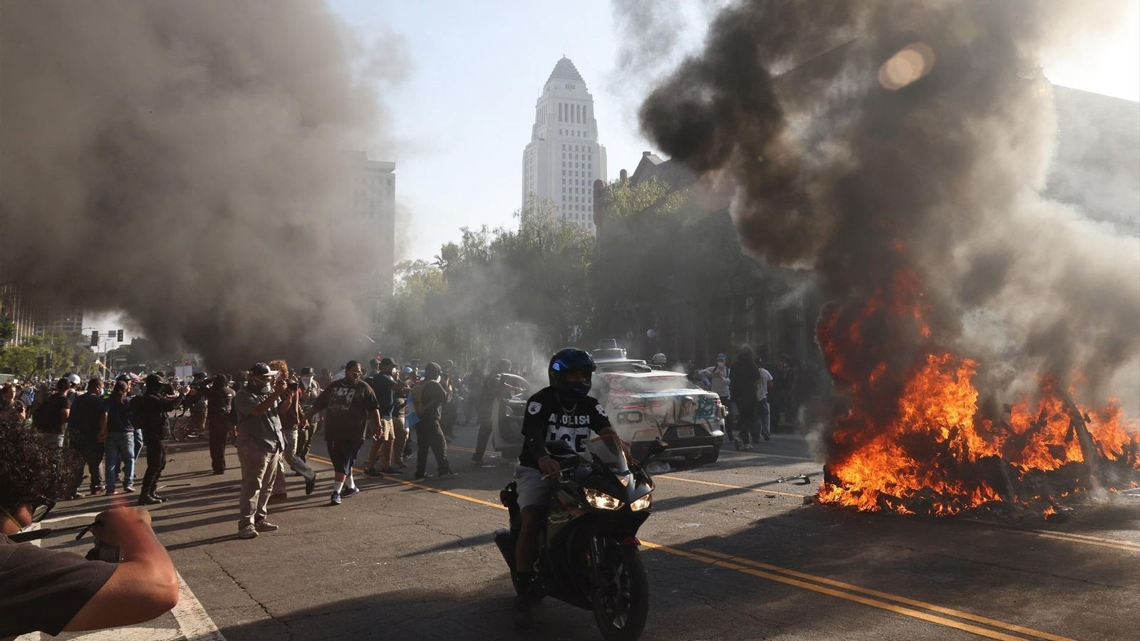 Un fuego en medio de una calle en Los Ángeles en medio de las protestas.