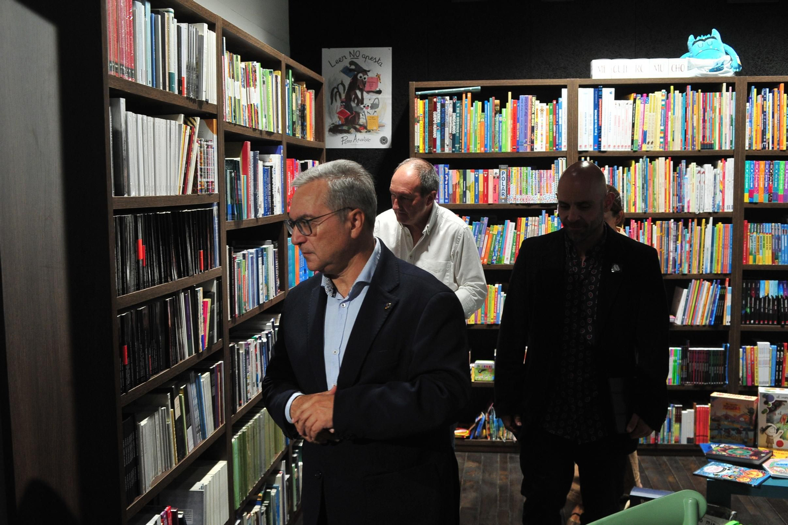 Luis Menor y Jose Ramón Martínez observan los libros disponibles.