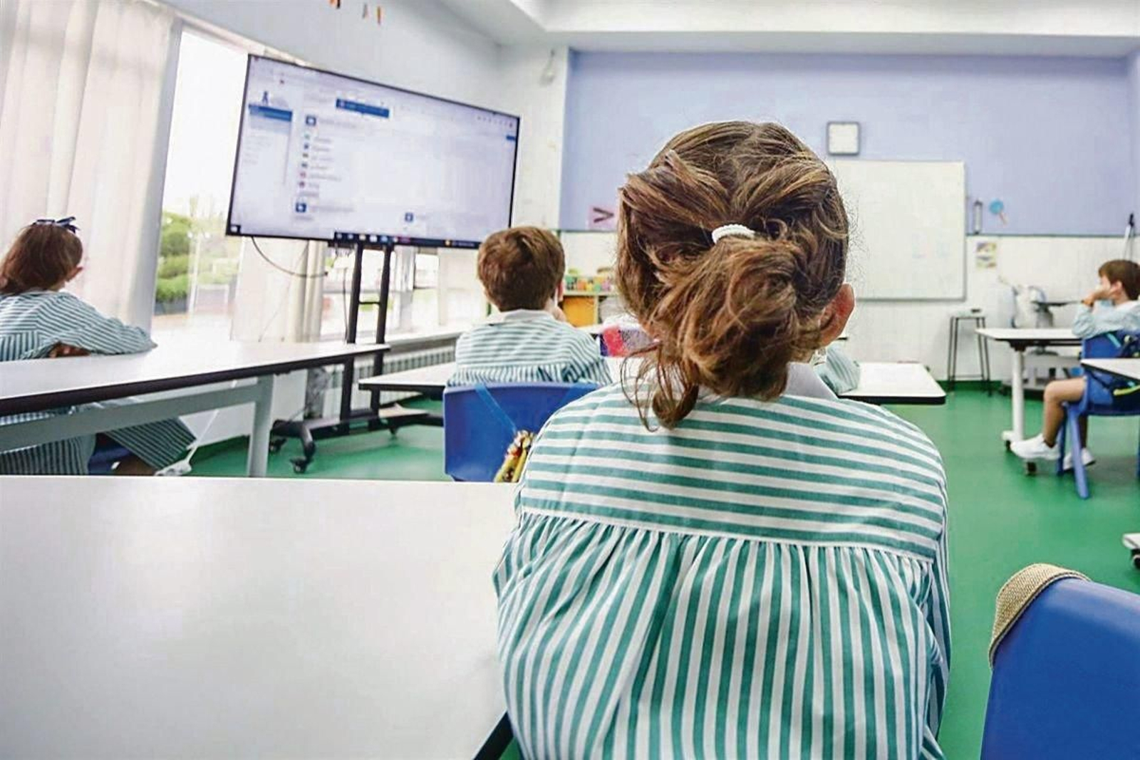 Niños miran a una pantalla durante una clase del colegio.