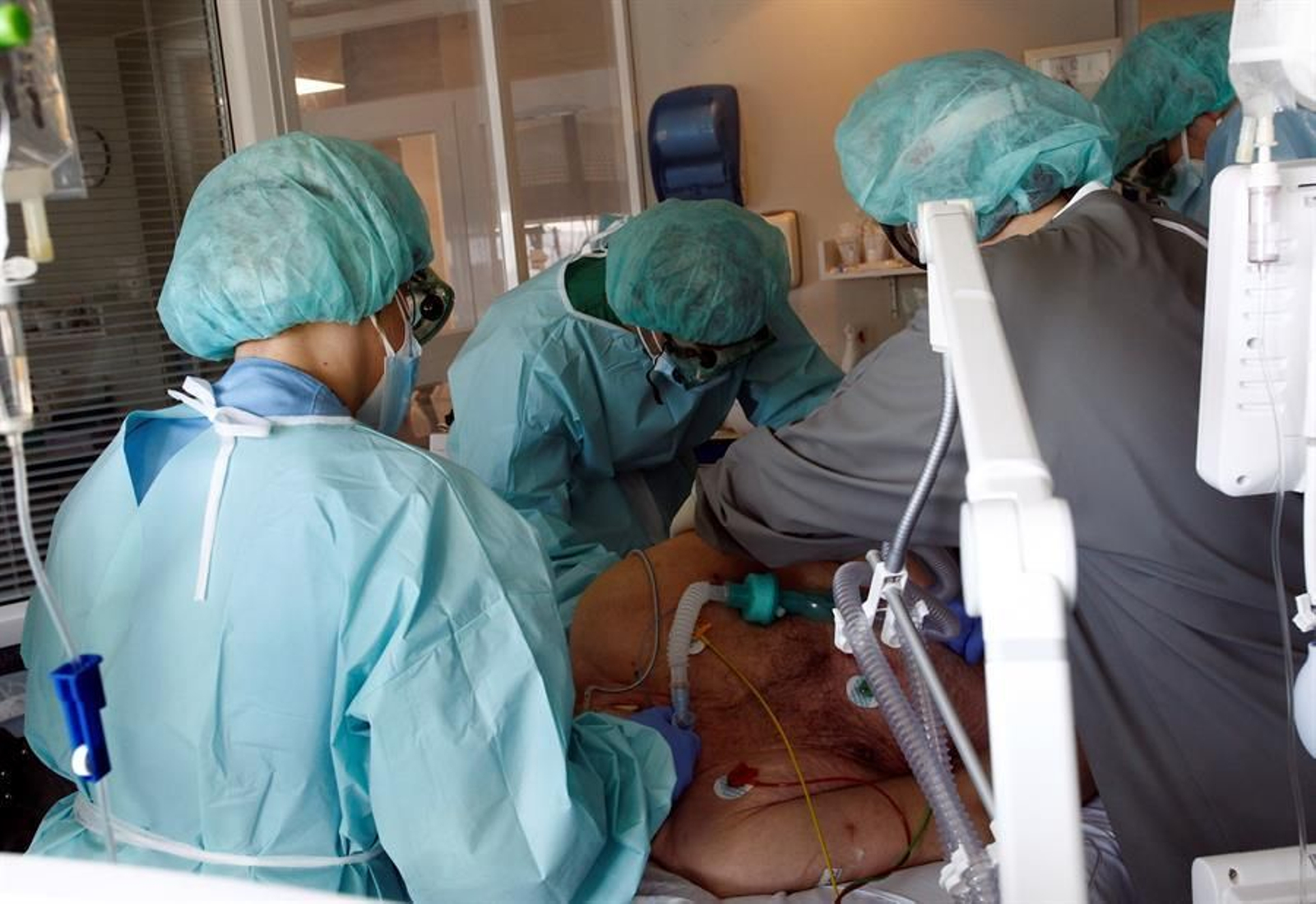 Varios sanitarios atienden a un paciente con COVID-19.