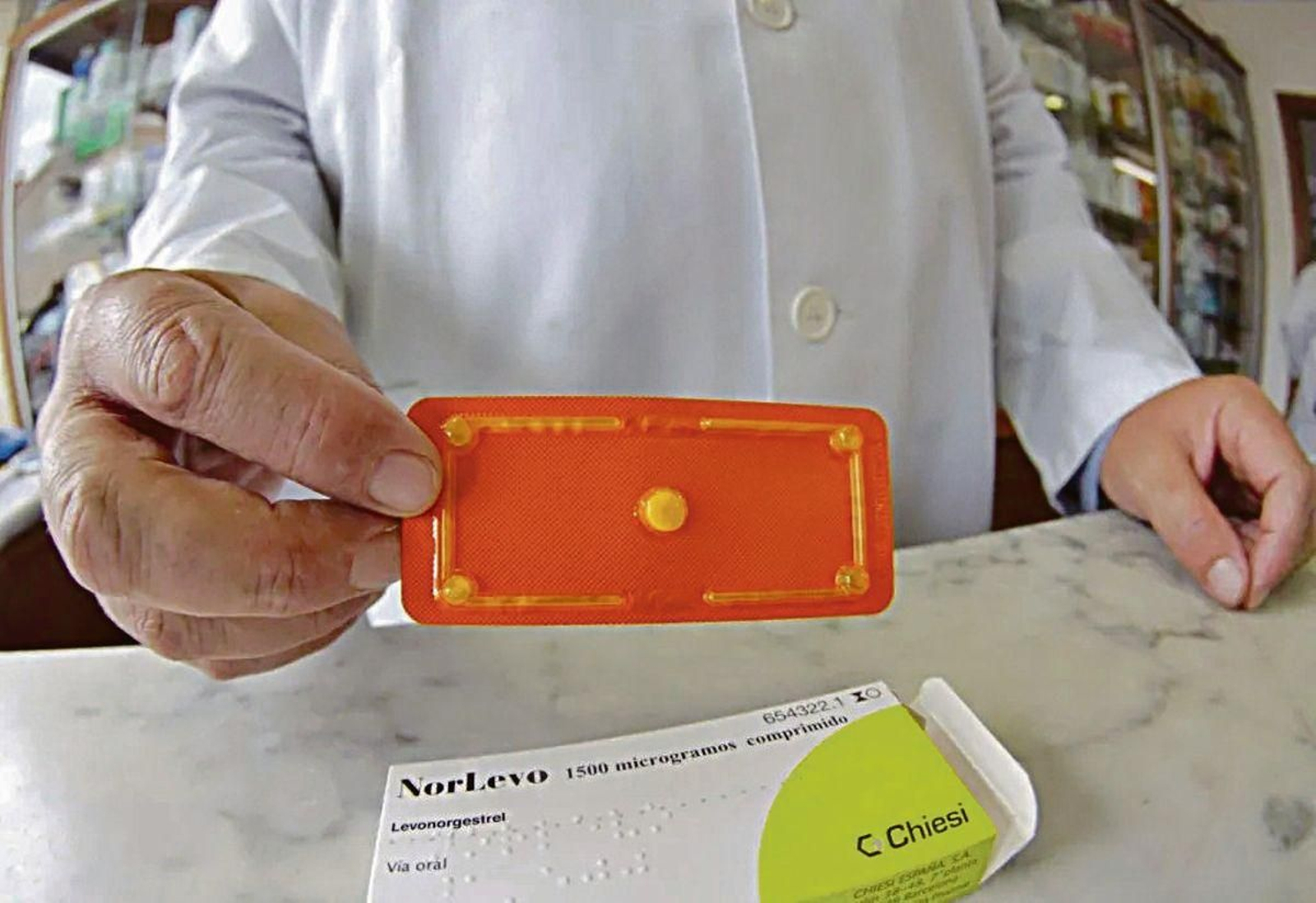 Un farmacéutico muestra una píldora poscoital.