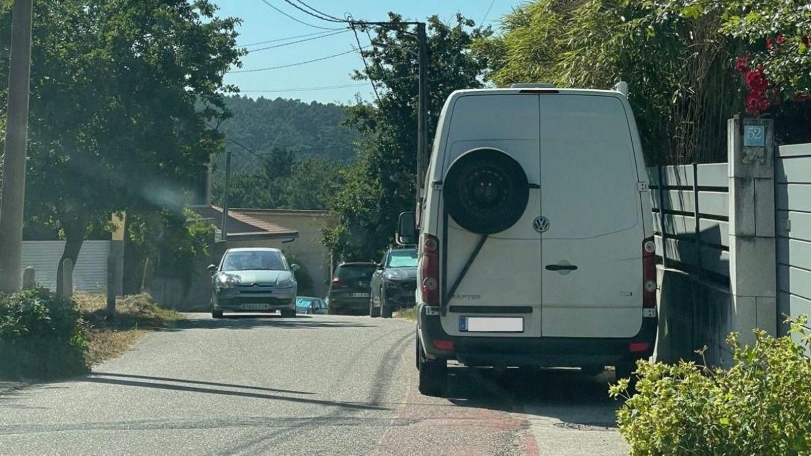 Vehículos mal estacionados en un vial de acceso a la playa de Barra.